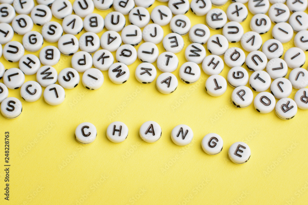 The word CHANGE made of plastic blocks on a yellow background with many letters on the top The word CHANGE made of plastic blocks on a yellow background with many letters on the top