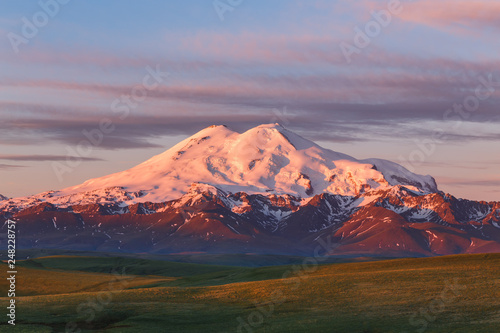 Mount Elbrus in summer morning at sunrise. Mountain landscape in North Caucasus, Karachay-Cherkessia, Russia