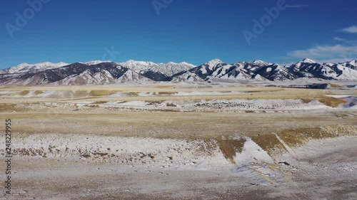 Aerial flying over winter field in Montana  scenic view of mountains photo