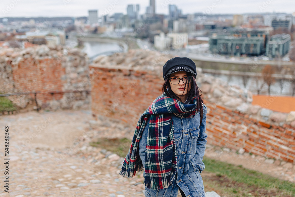 Stylish girl in jeans jacket walk at the Vilnius background on Gediminas Castle, Lithuania
