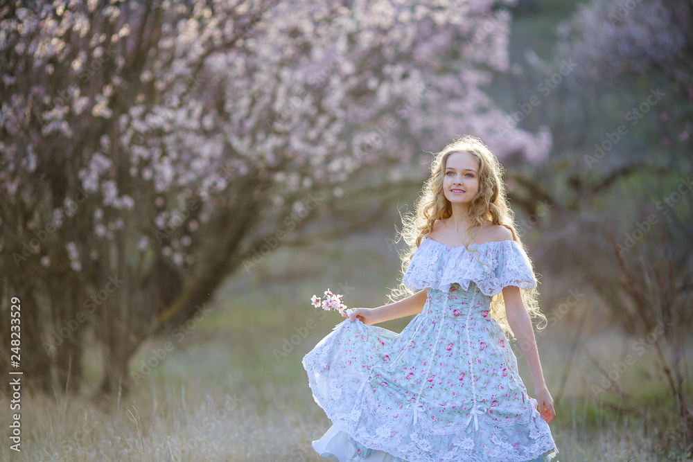 Sweet woman in a beautiful dress dancing in a park with long hair Sweet woman in a beautiful dress dancing in a park with long hair