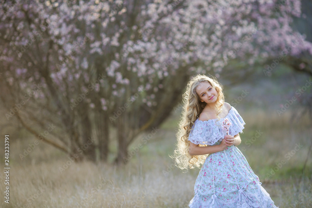 Sweet woman in a beautiful dress dancing in a park with long hair Sweet woman in a beautiful dress dancing in a park with long hair