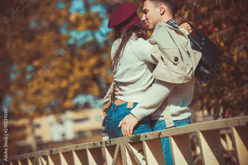 Handsome couple standing on the bridge in the park