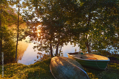 Peaceful morning landscape with fog and boats