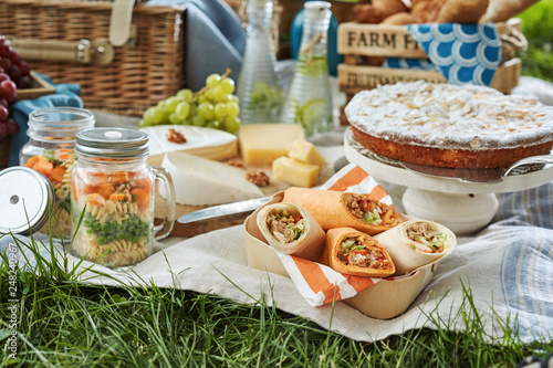 Delicious picnic food served outdoors on a rug photo