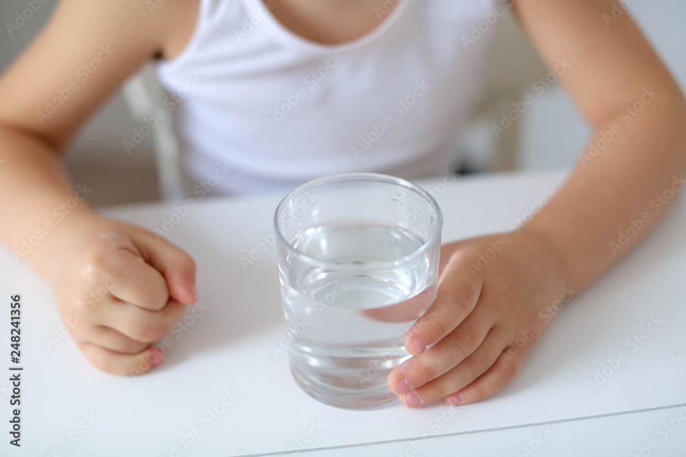 Cute smiling boy with glass of water isolated on a white background Cute smiling boy with glass of water isolated on a white background
