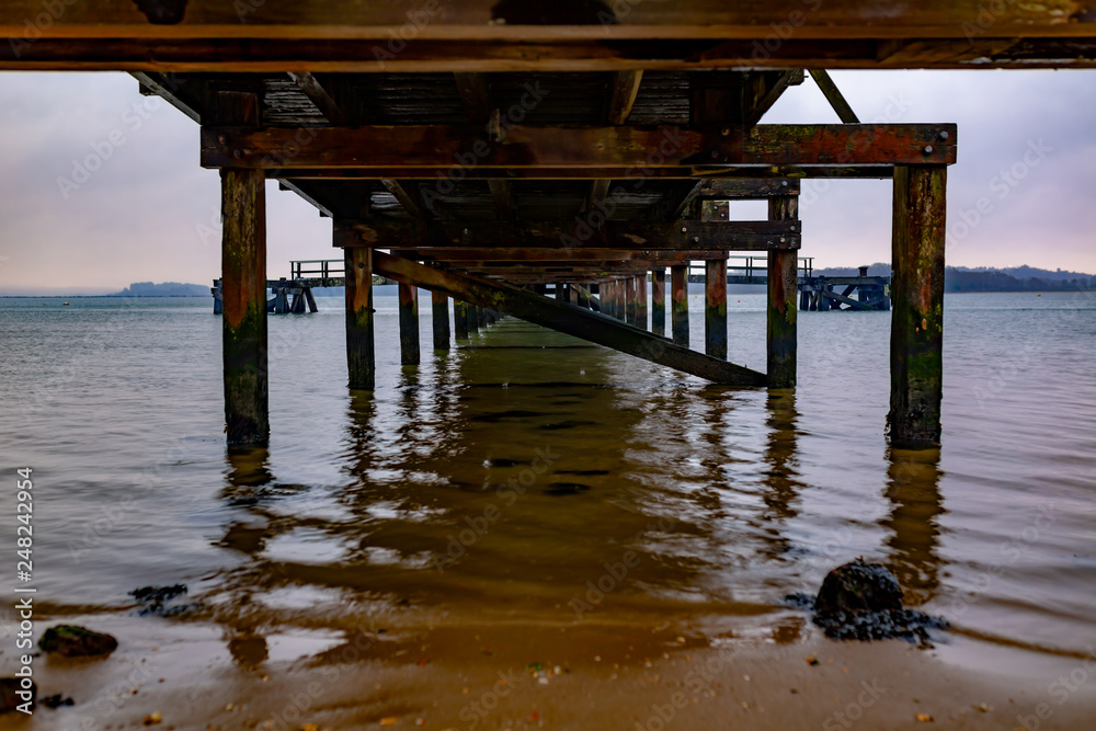 Under pier and cloudy sky