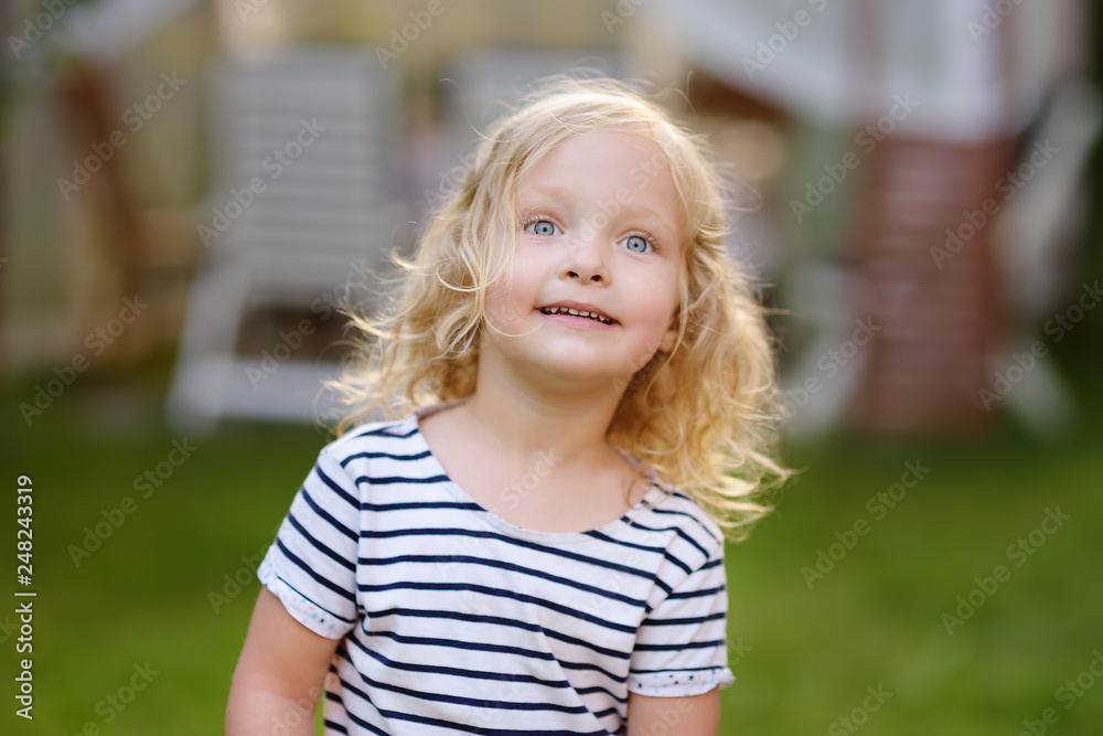 Cute toddler girl outdoors portrait in summer day. Smiling and charming child. Cute toddler girl outdoors portrait in summer day. Smiling and charming child.