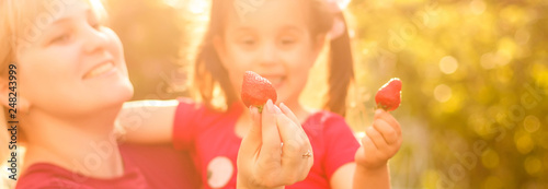 mother and her daughter strawberries photo