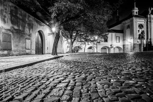 Photography Narrow cobbled street in old medieval town with illuminated houses by vintage street lamps, Novy svet, Prague, Czech Republic