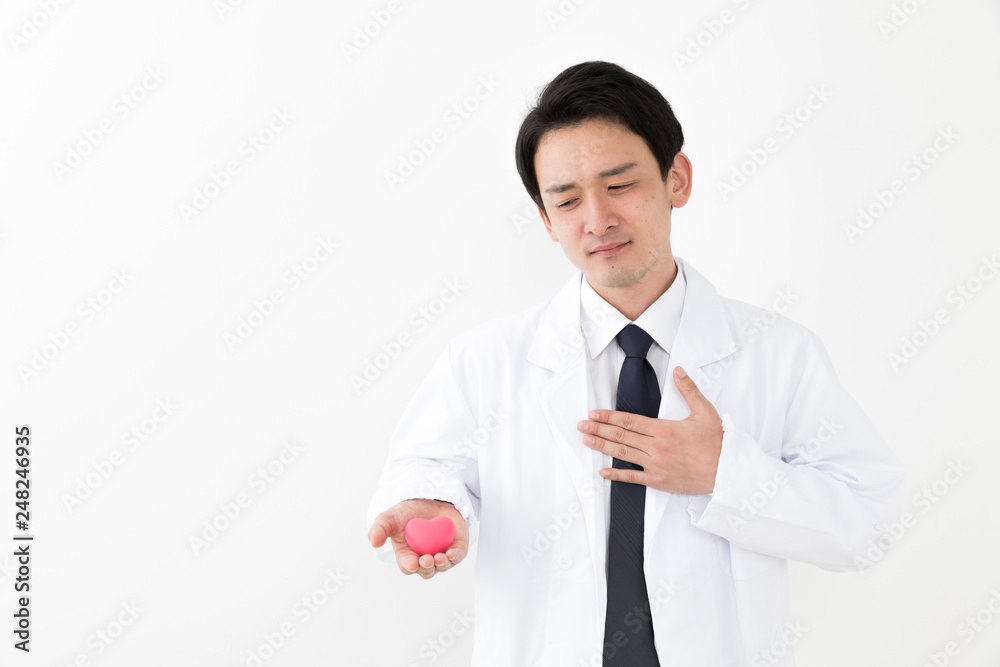 portrait of young asian doctor holding heart symbol isolated on white background portrait of young asian doctor holding heart symbol isolated on white background