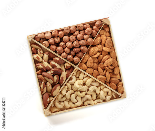 Assorted nuts. Set of nuts top view. Isolated on white background. Wooden box for nuts storage.
