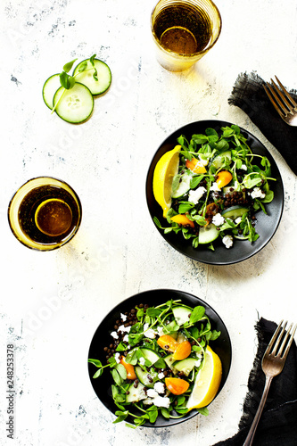 Black Lentil Pea Shoot Salad with Feta Vinaigrette photographed on a white background. photo