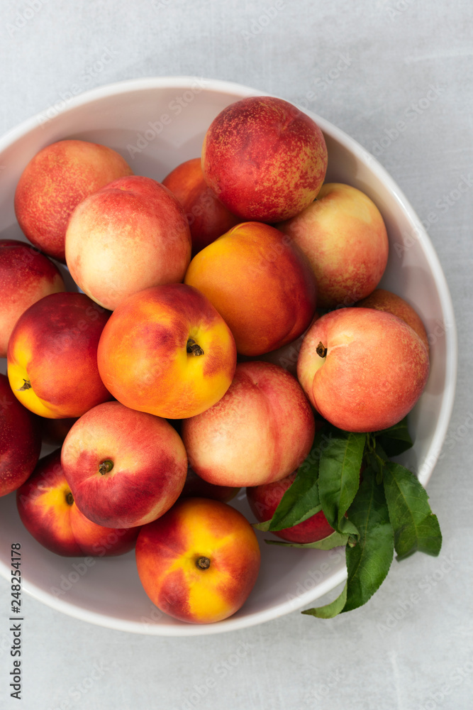 Whole red and yellow nectarines in a bowl. Whole red and yellow nectarines in a bowl.