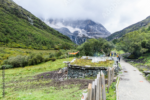 Beautiful scene in the Daocheng Yading National Nature Reserve (know as Nyidên in Tibetan), Ganzi, Sichuan, China.The Yangmaiyong Snow Mountain far away cover by fog. photo