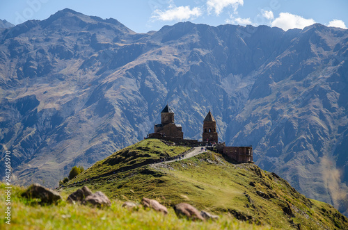 Holy Trinity Church in Kazbegi mountain range near Stepantsminda view Caucasus mountains in the background photo