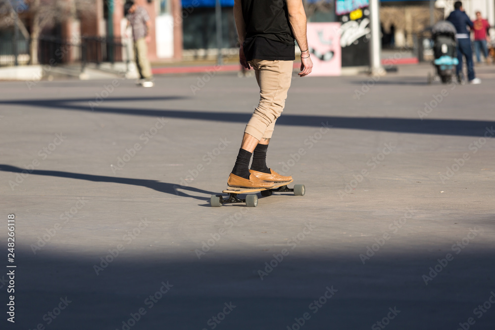 Person riding a skate board in an urban asphalt park