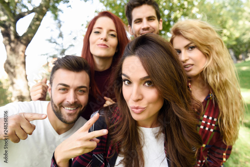 Group of friends taking selfie in urban background