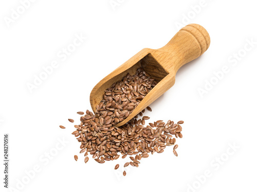 Linseeds or flax seeds on a wooden scoop or spoon seen almost directly from above isolated on white background