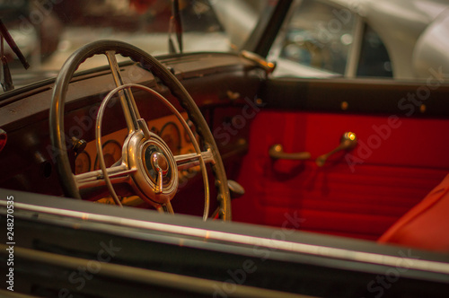 Old retro car steering wheel, red interior. © andreyphoto63