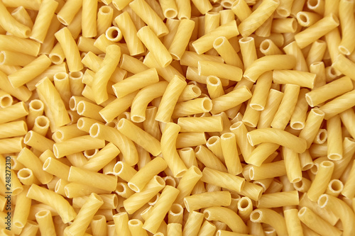 Tortiglioni italian pasta as background, top view