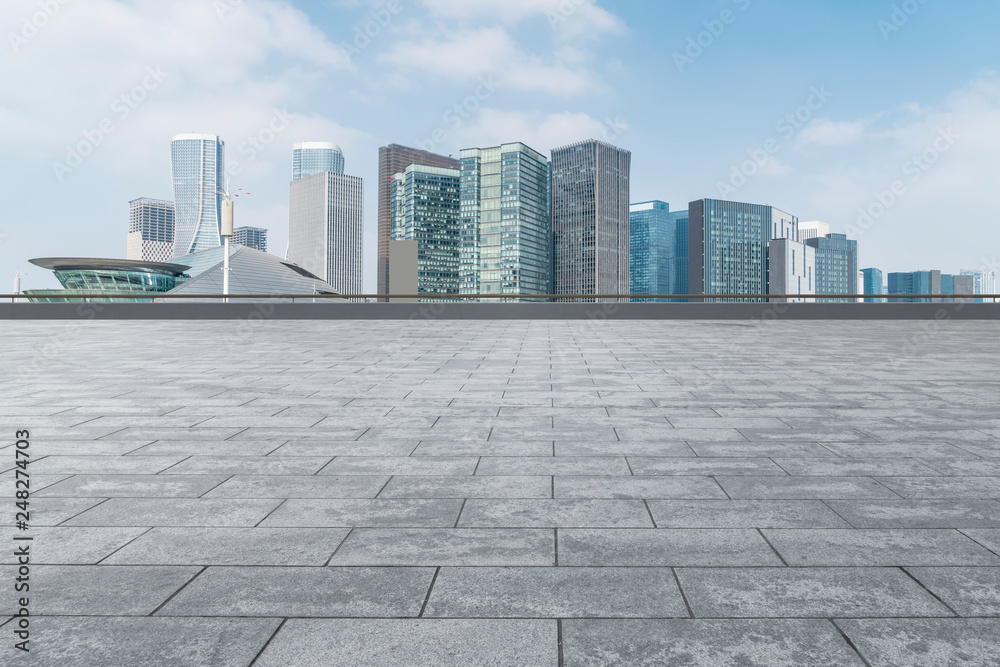 Empty Plaza floor tiles and the skyline of modern urban buildings in Hangzhou..