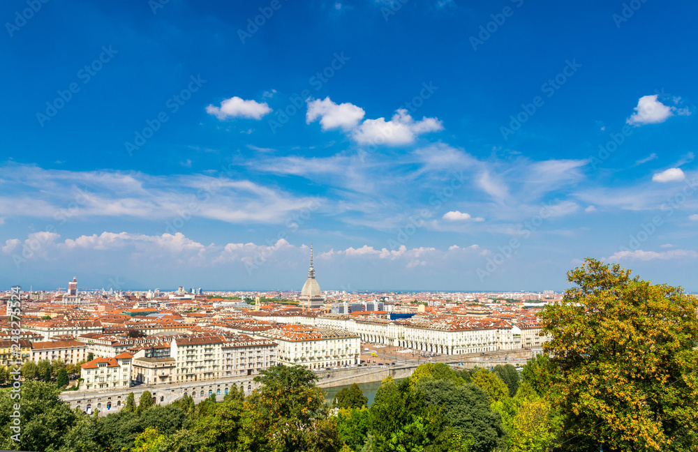Aerial top panoramic view of Turin city center skyline with Piazza Vittorio Veneto square, Po river and Mole Antonelliana building with high spire, blue sky white clouds background, Piedmont, Italy