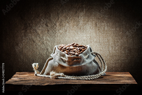 burlap bag of coffee beans on vintage wood
