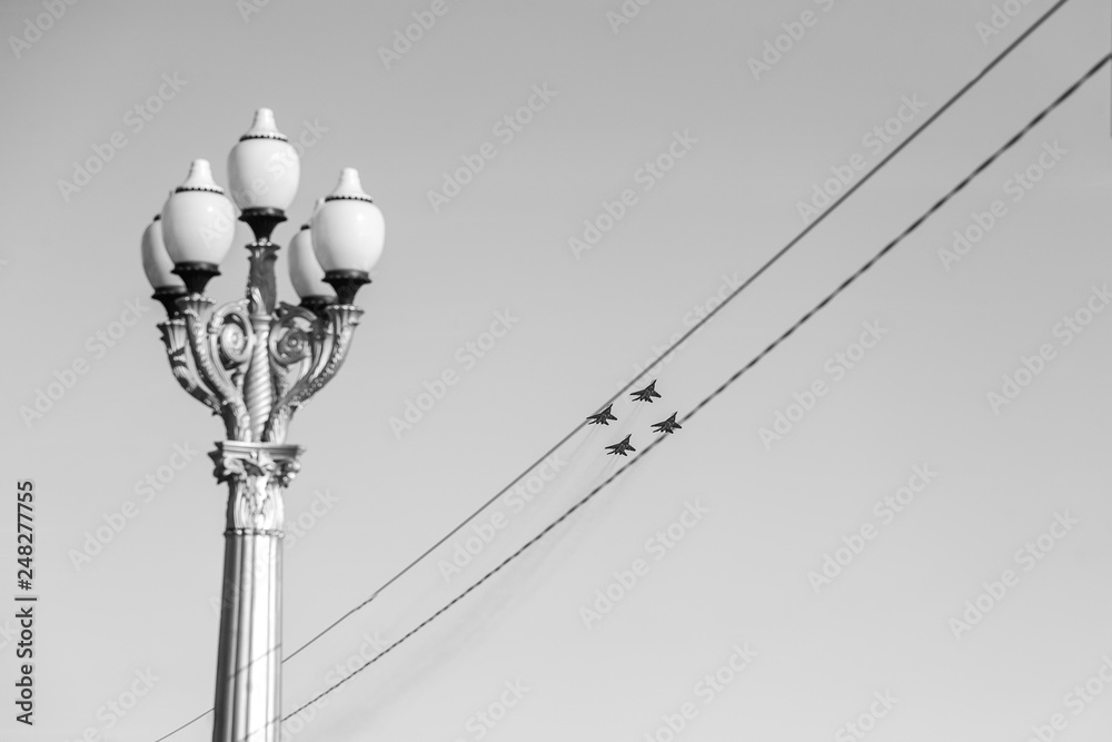 jet fighters flying in the diamond formation framed by wires jet fighters flying in the diamond formation framed by wires