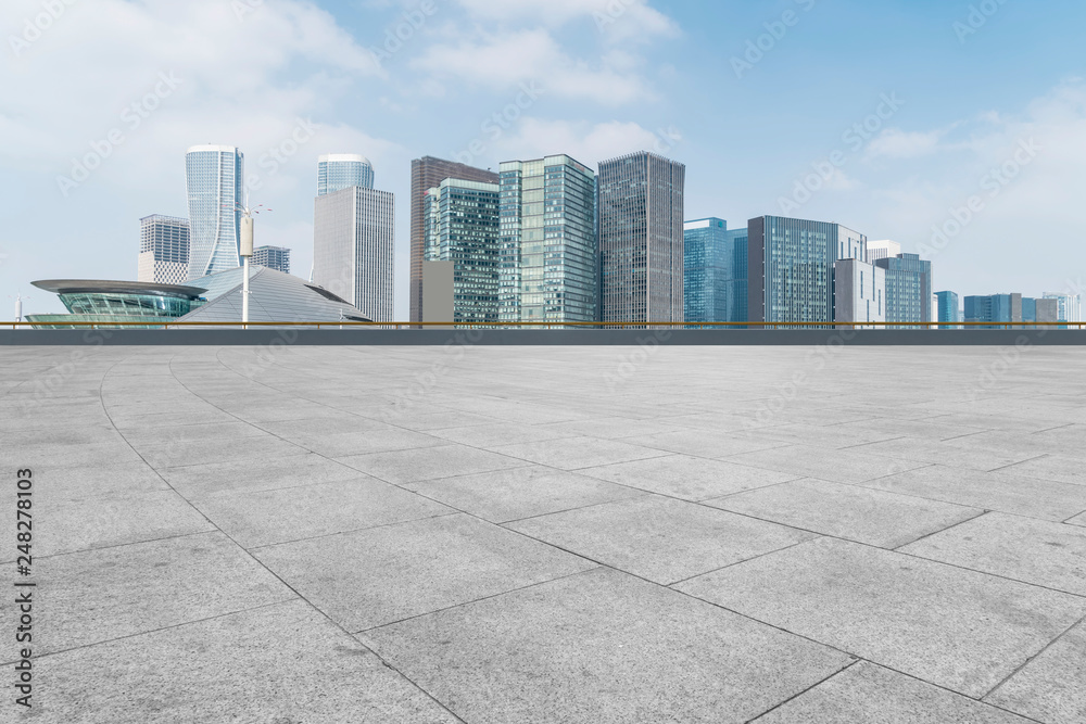 Empty Plaza floor tiles and the skyline of modern urban buildings in Hangzhou..