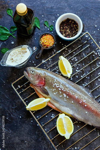 Haute cuizine: raw salmon fish prepared to be cooked at the grill stuff, with cut lemons, sauce and sea salt photo