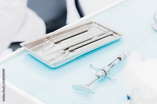 Close-up of a staminological instrument next to a metal syringe. Dental equipment. Dental hygiene and healthcare concept