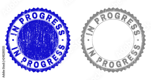 Grunge IN PROGRESS stamp seals isolated on a white background. Rosette seals with grunge texture in blue and grey colors. Vector rubber watermark of IN PROGRESS tag inside round rosette.