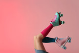 Woman with vintage roller skates on color background, closeup. Space for text