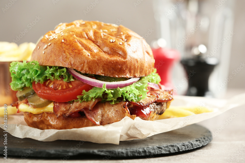 Delicious burger with bacon on slate plate Delicious burger with bacon on slate plate