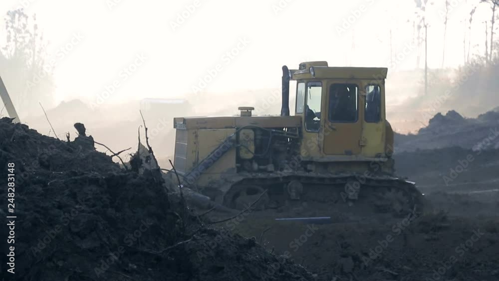 Morning, fog, the work of excavators and bulldozers on the construction site. Ground alignment Morning, fog, the work of excavators and bulldozers on the construction site. Ground alignment