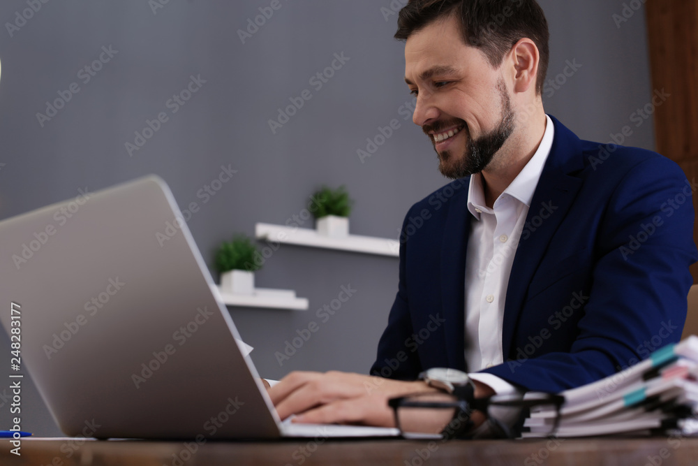 Businessman working with laptop and documents at table in office Businessman working with laptop and documents at table in office