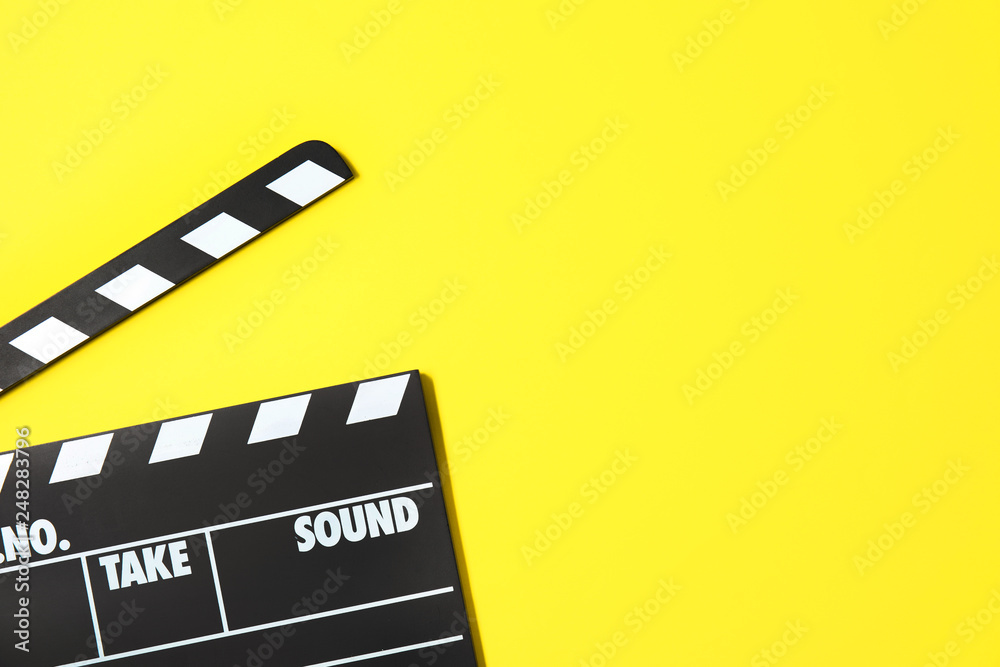 Clapperboard on color background, top view with space for text. Cinema production