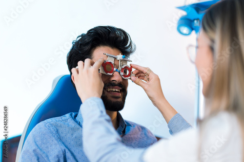 Optometrist checking patient eyesight and vision correction photo