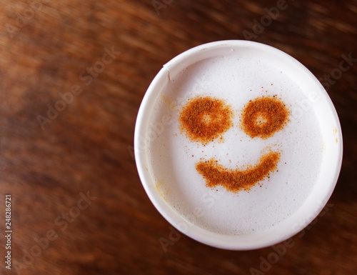 smiling face on cappuccino coffee takeaway, top view and space for text