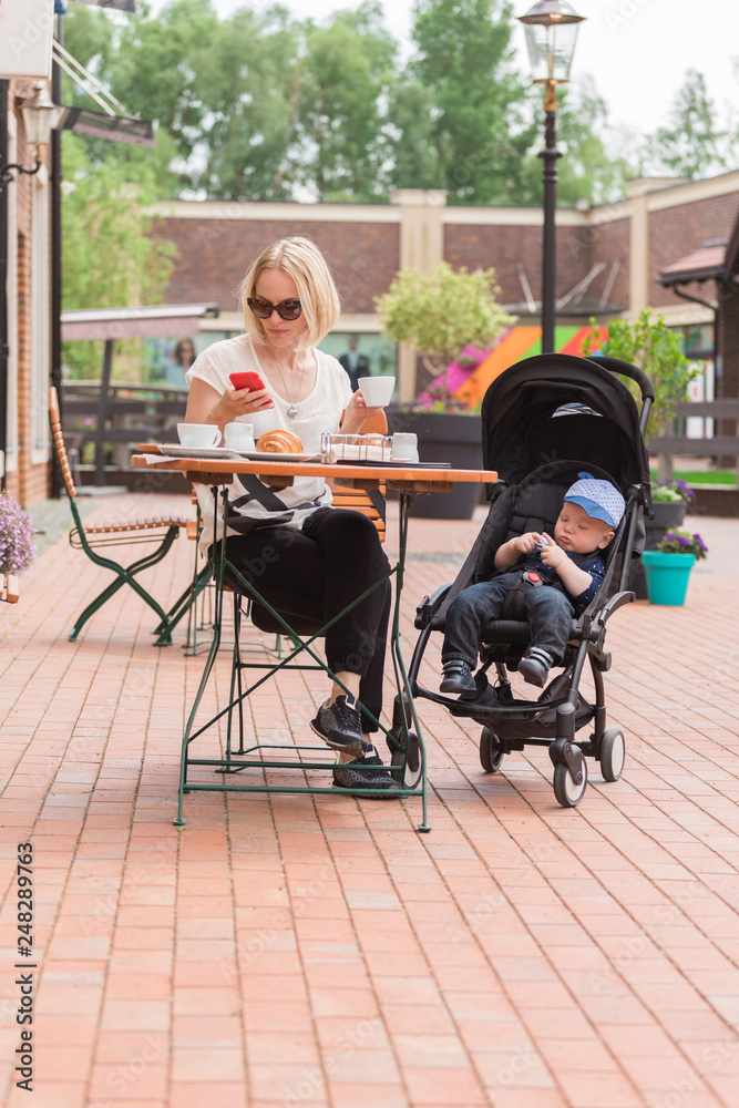 Young mother with her one-year-old child in a street cafe Young mother with her one-year-old child in a street cafe