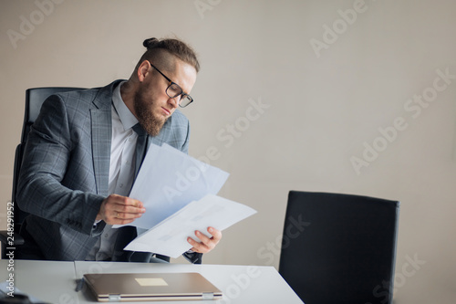 serious businessman makes financial report. office worker analyzes profits.close up portrait. clever employee working with paper. copy space. boss making a report in the office