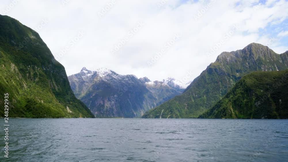 Handheld shot from boat sailing towards island with green cliffs and high mountains Handheld shot from boat sailing towards island with green cliffs and high mountains