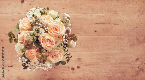 Wedding bouquet of pink roses on wooden background photo