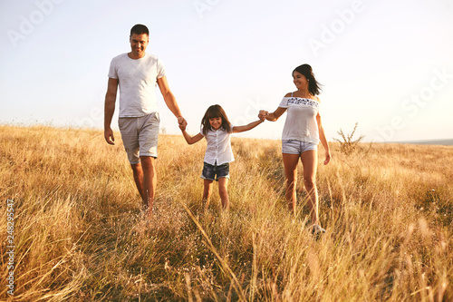 Happy family playing on nature in summer at sunset.