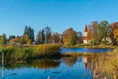 Araisi Lutheran Church standing on the calm lake shore in sunny autumn day. Ancient church reflecting in the calm blue smooth surface of the lake.