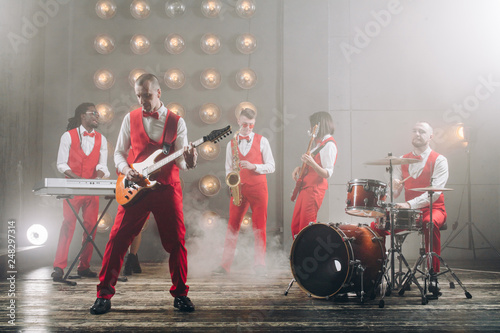 stylish band in red suits performing at the consert. show, entertainmnet concepts photo