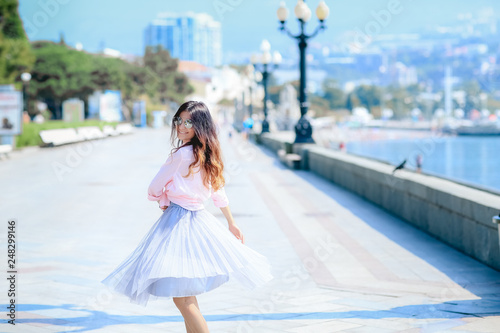 Girl walking along the seafront in dress in hot summer day © ElenaBatkova