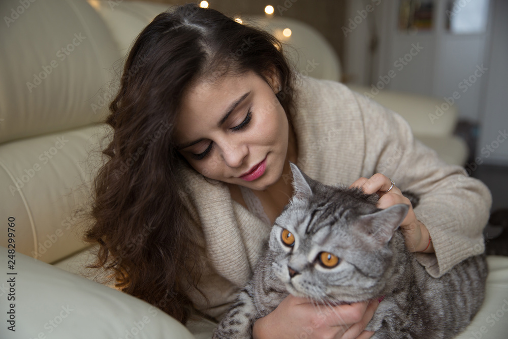 Beautiful girl is lying next to a cat