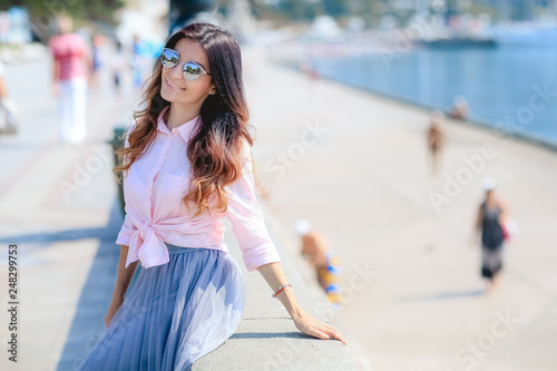 Happy woman by posing near the sea in a hot summer day.